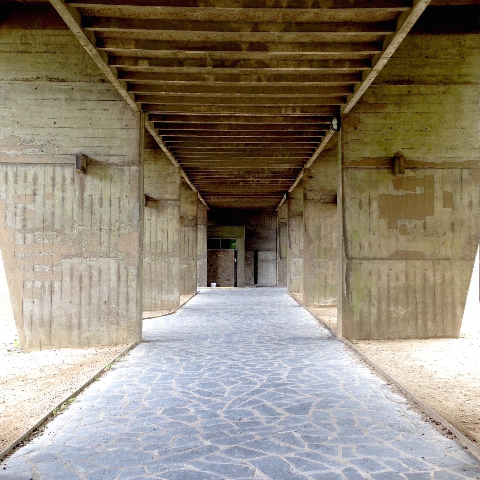 Vue sous l’immeuble : le béton est omniprésent.